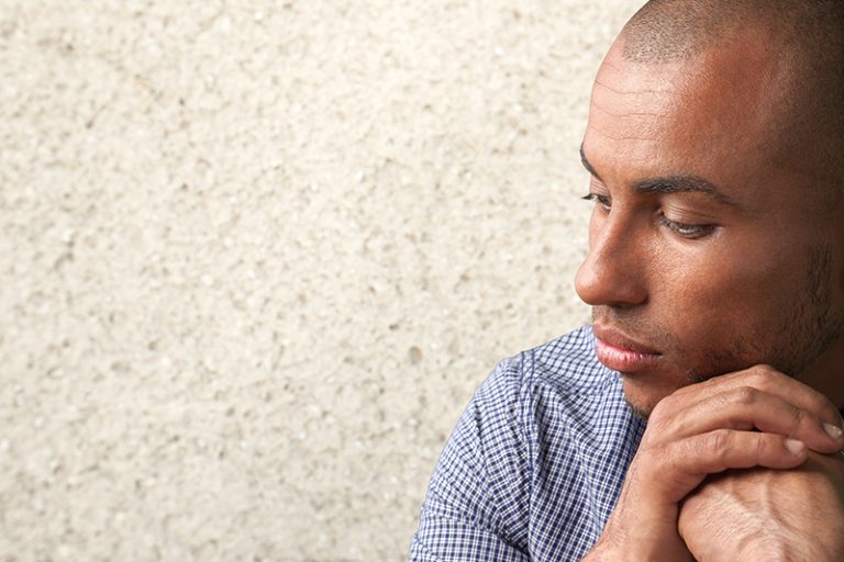 Sad young man in front of a wall