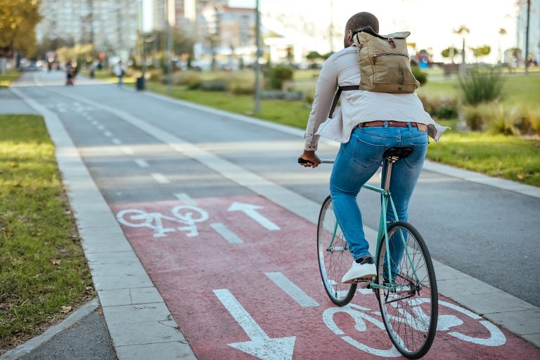 Man rides a bicycle in the city on a bicycle path.