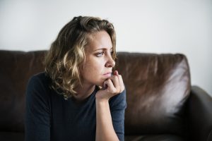 Woman sitting on a sofa looking sad